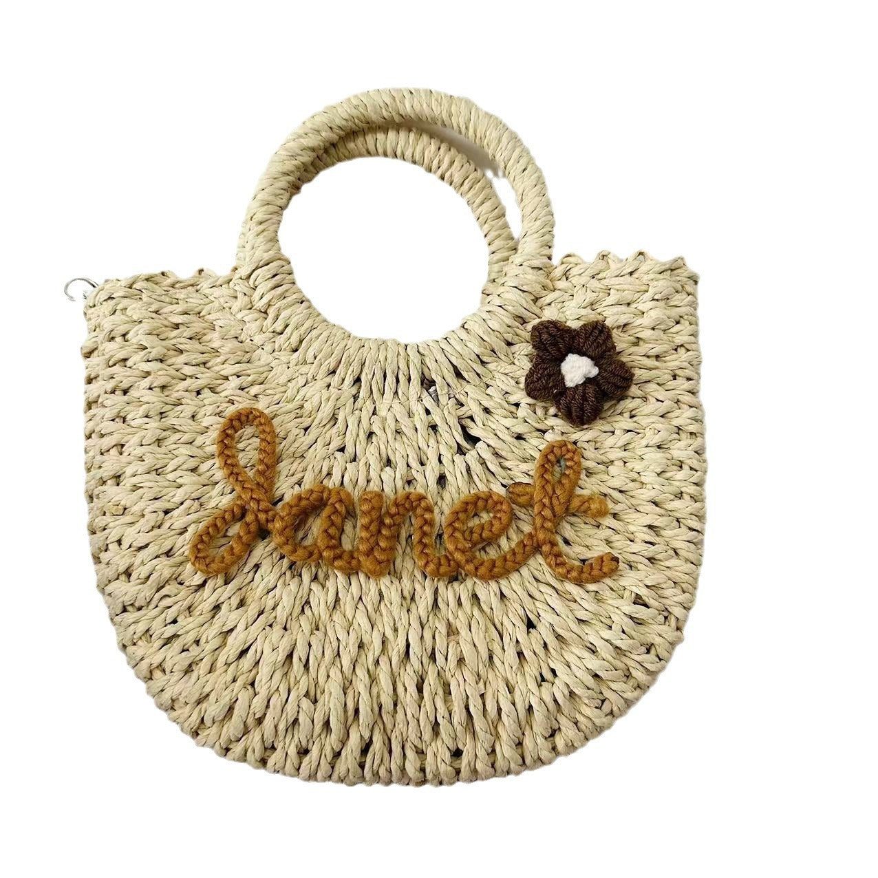 Grass woven handbag with "Janet" name design, seaside vacation style, featuring a straw tote appearance with a small flower detail.