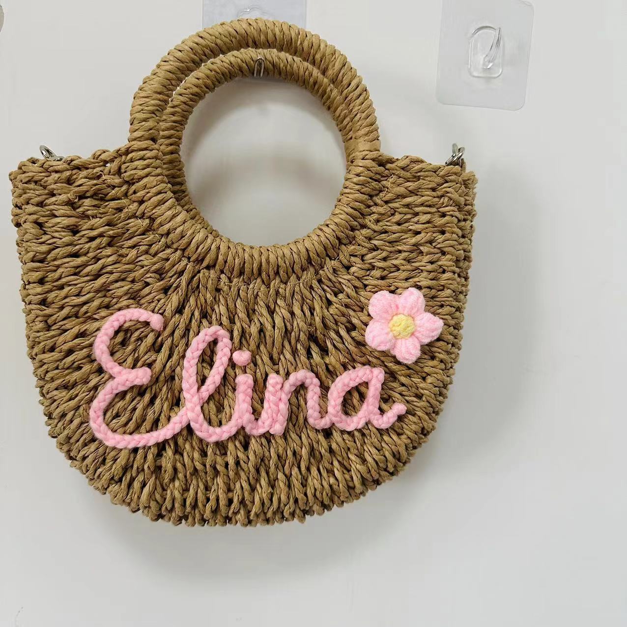 Grass woven handbag with personalized letter name, featuring a pink flower design, seaside vacation style.