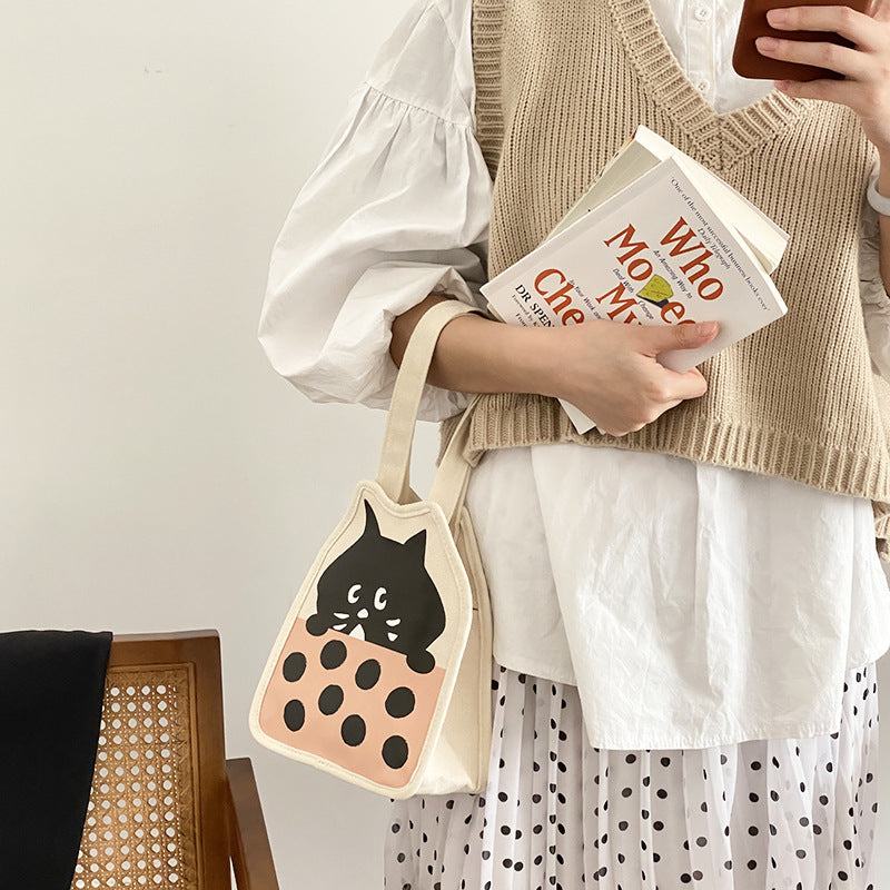 Canvas bag with cute kitten illustration, vertical square shape, magnetic snap, casual hand-carrying style.