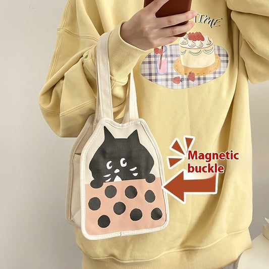 Canvas bag with cute kitten illustration, magnetic snap, casual hand-carrying style.